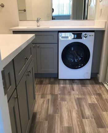 a white washer and dryer in a kitchen with wooden floors